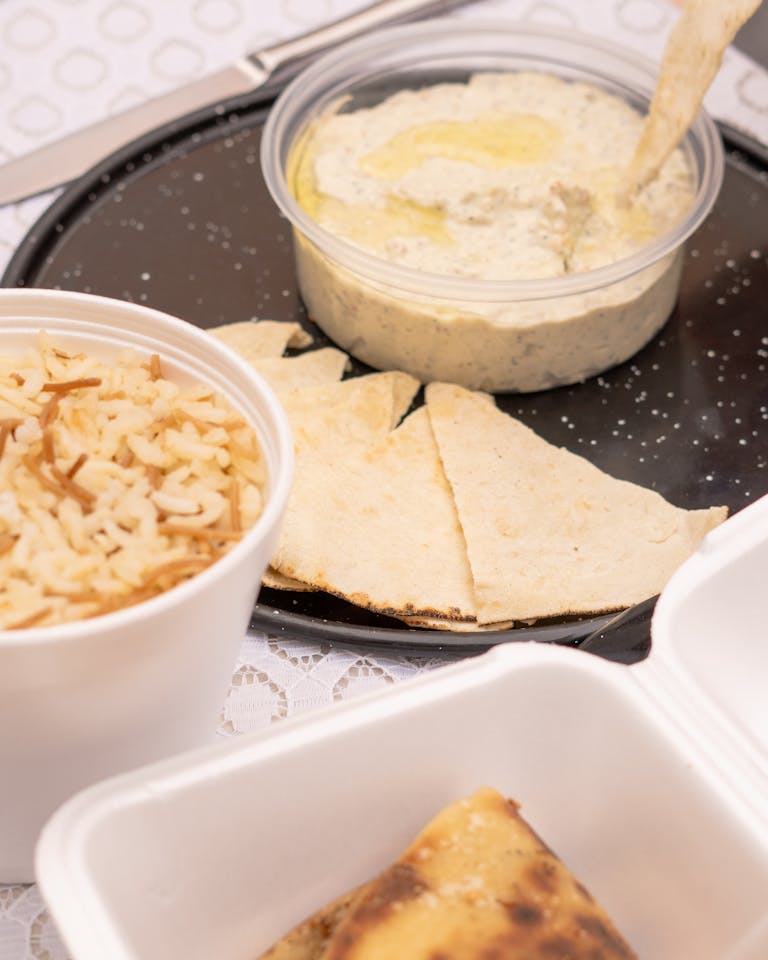 Delicious Middle Eastern meal featuring creamy hummus, pita bread, and seasoned rice.